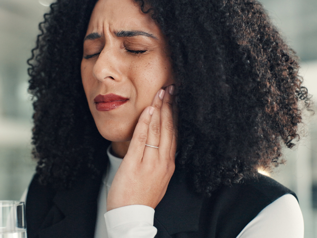 Woman clenching jaw from stress showing effects on oral health