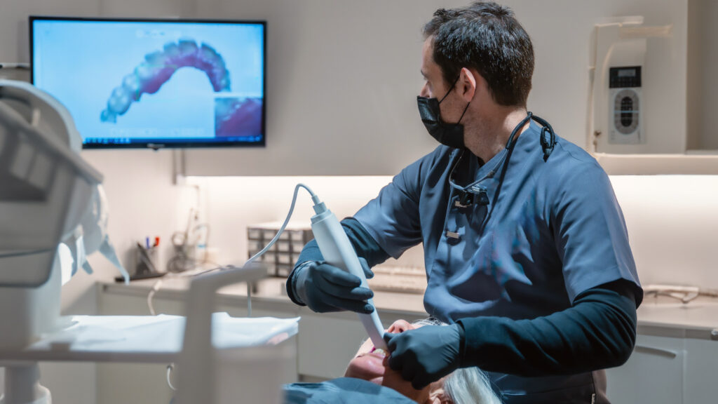 Modern cone beam CT scanner rotating around patient head for 3D dental imaging
